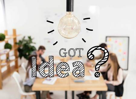 selective focus of light bulb and multicultural group of marketing managers working in office, got idea question signsの写真素材