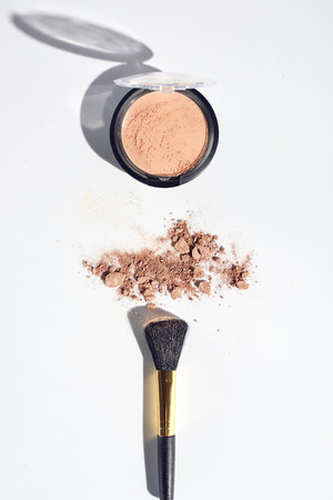 Scattered face powder with brush on white backgroundの写真素材