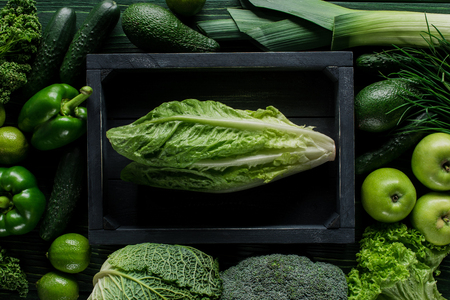 Top view of cabbage in wooden box between green vegetables, healthy eating conceptの写真素材