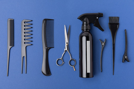 Flat lay with black hairdressing equipment, isolated on blue backgroundの写真素材