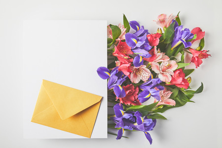 Beautiful floral bouquet, blank card and envelope on grey backgroundの写真素材