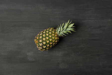 Top view of fresh ripe pineapple on dark tabletopの写真素材