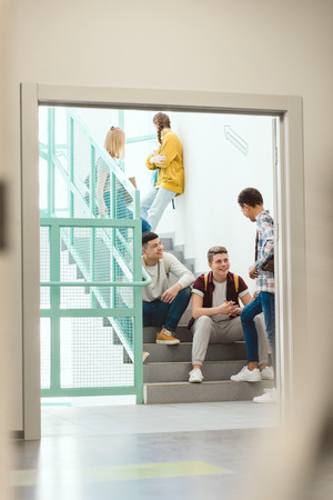 Group of high school students spending time on stairs at school on breakの写真素材