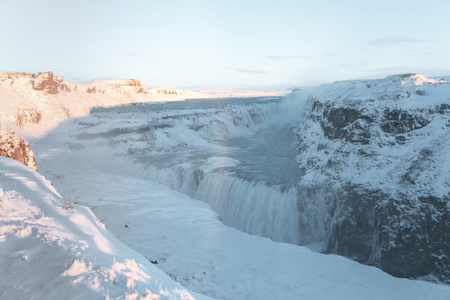 Beautiful Icelandic landscape with snow-covered rocks and Gullfoss waterfallの写真素材