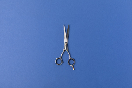 Top view of scissors, isolated on blue background