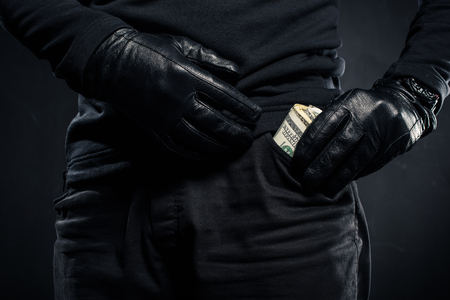 Close-up view of dollar banknotes in pocket of thiefの写真素材