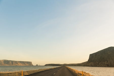 Empty asphalt road and water in Icelandの写真素材