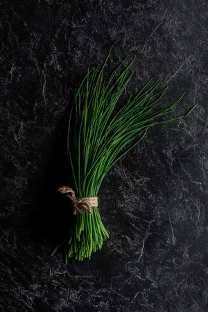 Top view of bunch of chives on concrete table, healthy eating conceptの写真素材
