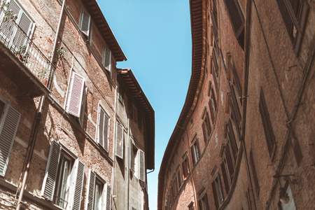 Red bricks building facade in historical part of Siennaの写真素材