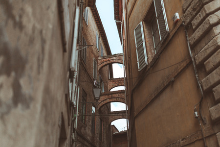 Arch in narrow street in historical quarter of Siennaの写真素材