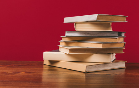 Floor with stack of different books on red background