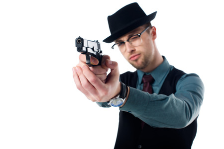 Portrait of spy agent in hat and eyeglasses with gun isolated on white backgroundの写真素材