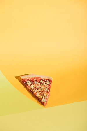 Close up view of piece of Italian pizza on colorful backgroundの写真素材