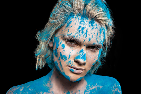 Portrait of attractive girl in blue holi powder, isolated on black backgroundの写真素材