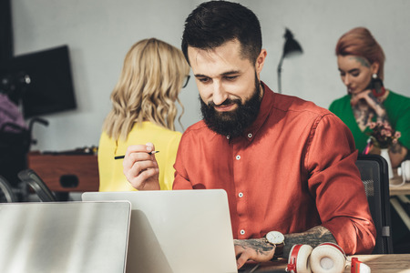 selective focus of designer and colleagues working behind in office