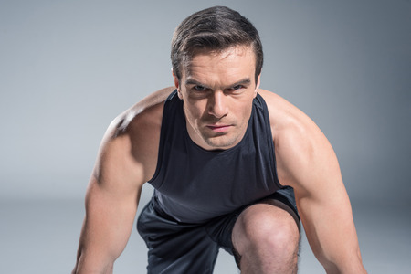 Confident sportsman getting ready for work out on grey backgroundの写真素材