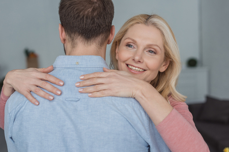 portrait of smiling mother hugging grown sonの写真素材