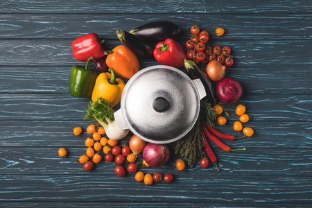 top view of ripe organic vegetables around pan on wooden tableの写真素材