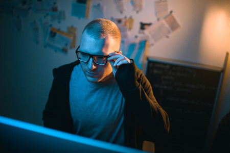 high angle view of young hacker developing malware in dark room