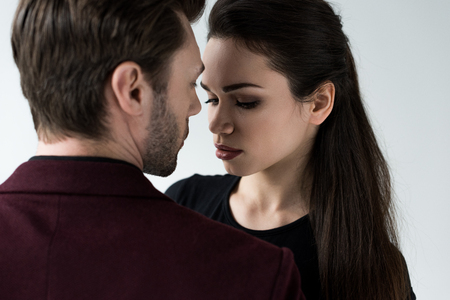 attractive sensual couple looking at each other, isolated on greyの写真素材