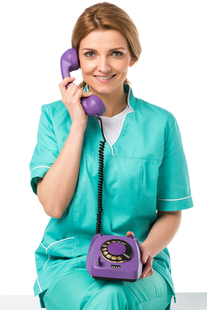 portrait of smiling veterinarian talking on telephone isolated on whiteの写真素材