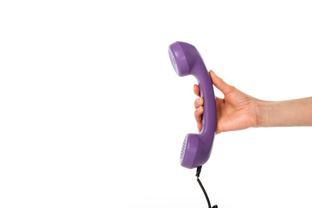 cropped shot of woman holding purple telephone tube in hand isolated on whiteの写真素材