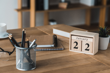 Stationery and glasses on wooden table in light officeの写真素材