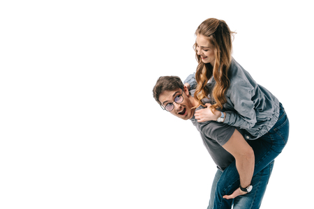 happy boyfriend giving piggyback to girlfriend isolated on whiteの写真素材