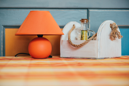 close-up view of decorative orange lamp and wooden box with spices on table in restaurantの写真素材