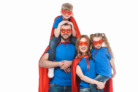 cheerful family of superheroes smiling at camera isolated on whiteの写真素材
