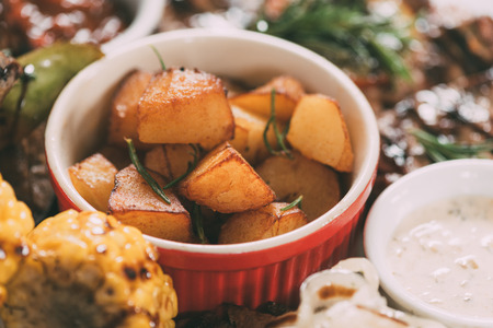 close-up view of delicious roasted potatoes with grilled vegetables and meatの写真素材
