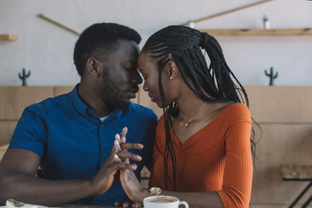 portrait of tender african american couple on romantic date in coffee shopの写真素材