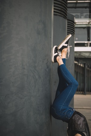 Low section of girl standing upside down near columnsの写真素材