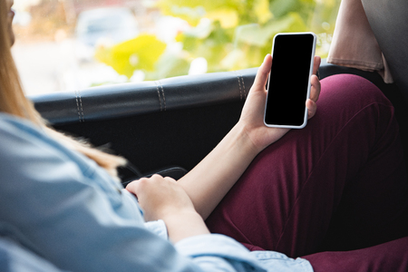 Cropped image of woman using smartphone with blank screen during trip on busの写真素材
