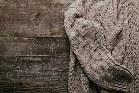 Top view of grey knitted sweater on wooden tabletopの写真素材