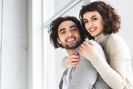 Smiling young couple looking at camera at homeの写真素材