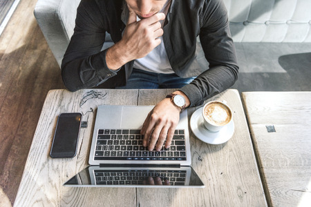 High angle view of thoughtful freelancer working with laptop in cafeの写真素材