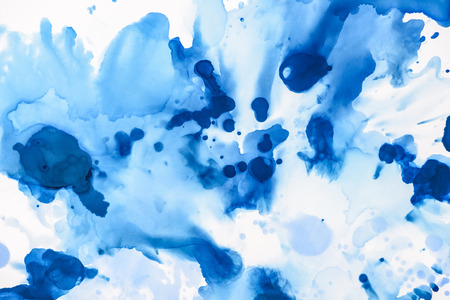 Blue and light blue splashes of alcohol ink on white as abstract backgroundの写真素材