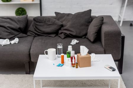 Table with various medicines and couch at living roomの写真素材