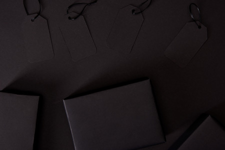 Top view of blank price tags and packages on black surface, black Friday conceptの写真素材