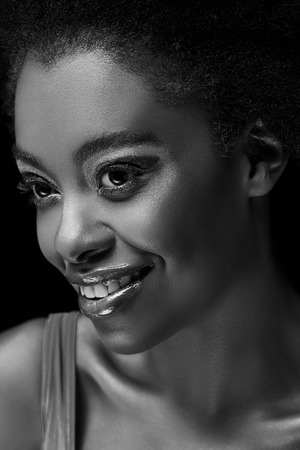 Black and white photo of beautiful smiling African American woman isolated on black backgroundの写真素材