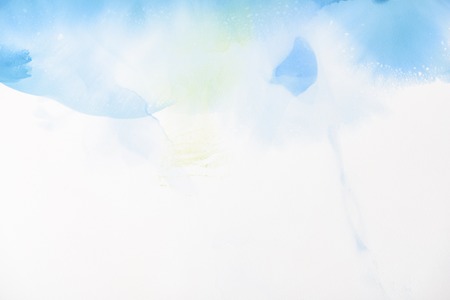 Light blue and green splashes of alcohol inks on white as abstract backgroundの写真素材