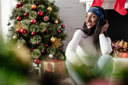 Smiling attractive African American woman looking away at home, Christmas conceptの写真素材