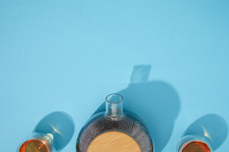 Top view of teapot and cups with fresh tea on blue backgroundの写真素材