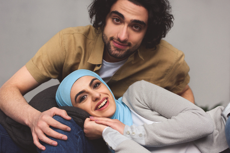 Smiling Muslim couple looking at camera at homeの写真素材