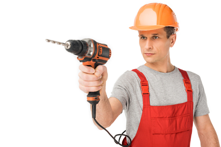 Professional builder in overalls and hardhat holding drill isolated on white backgroundの写真素材