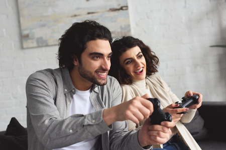 Smiling young couple playing video game at homeの写真素材