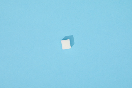 Sweet white sugar cube with shadow on blue backgroundの写真素材