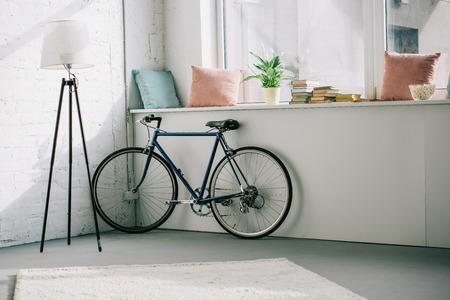 Bicycle near windowsill in living roomの写真素材
