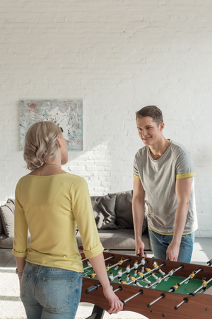 Couple playing table foosball at homeの写真素材